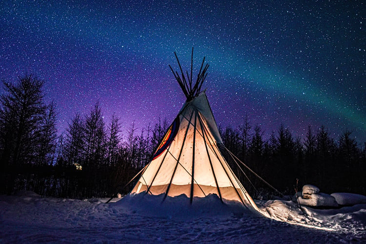 Image of a teepee beneath the northern lights.